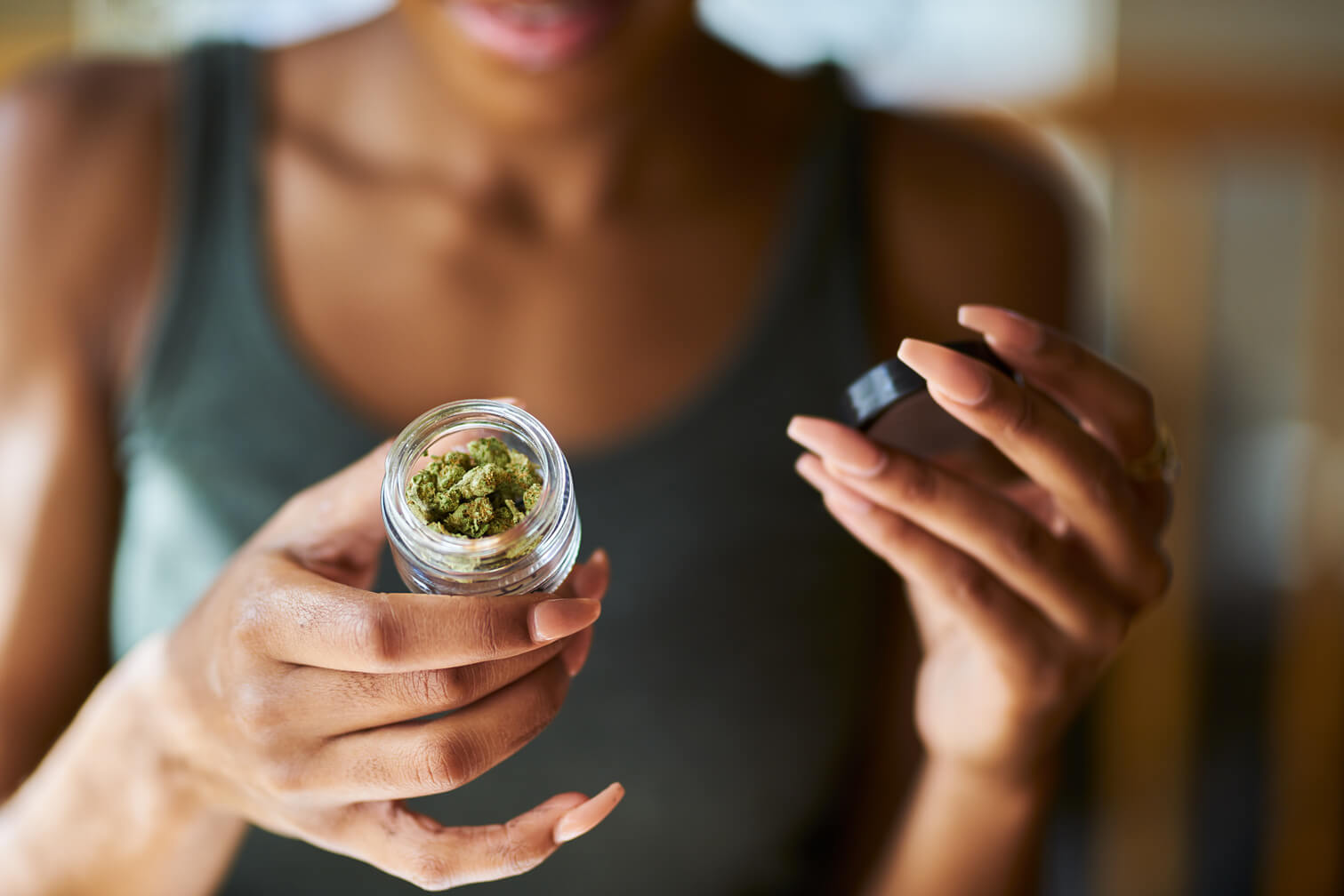Woman opening bottle of legal marijuana