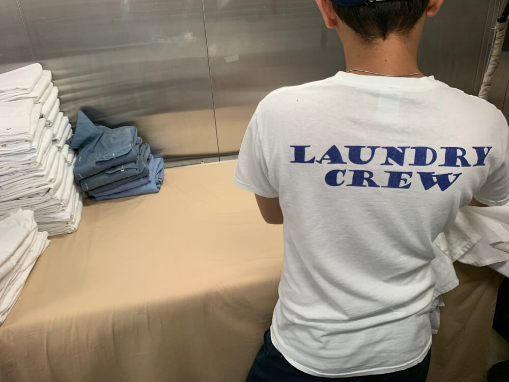 Laundry worker folding a towels - addon costs for a cruise