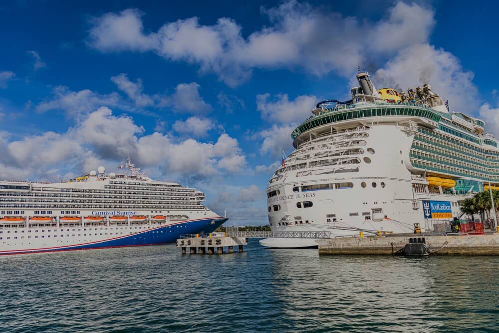 A water level view of the Independence of the Seas and Carnival Sunrise cruise ships